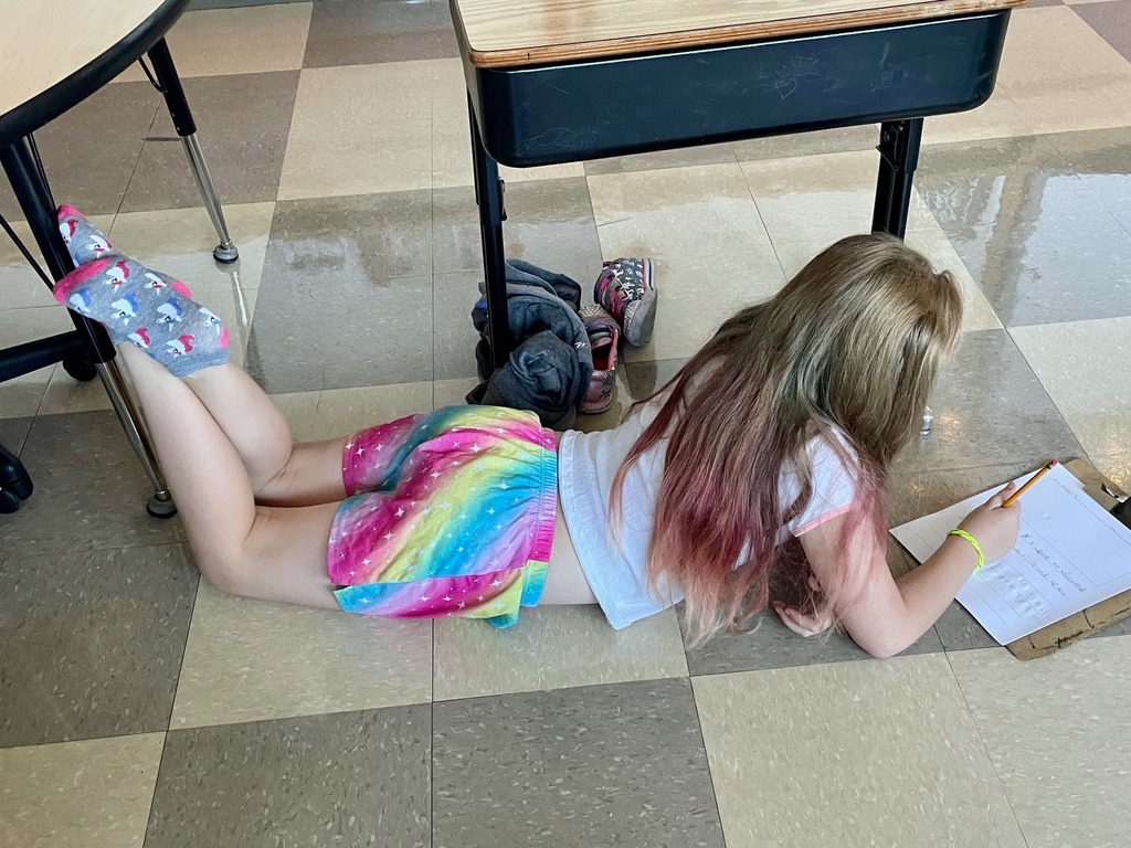 Girl lying on floor writing