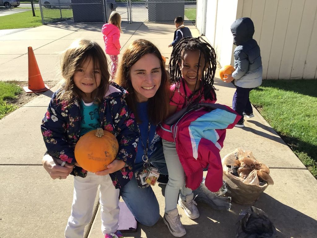 Teacher with two students and pumpkin