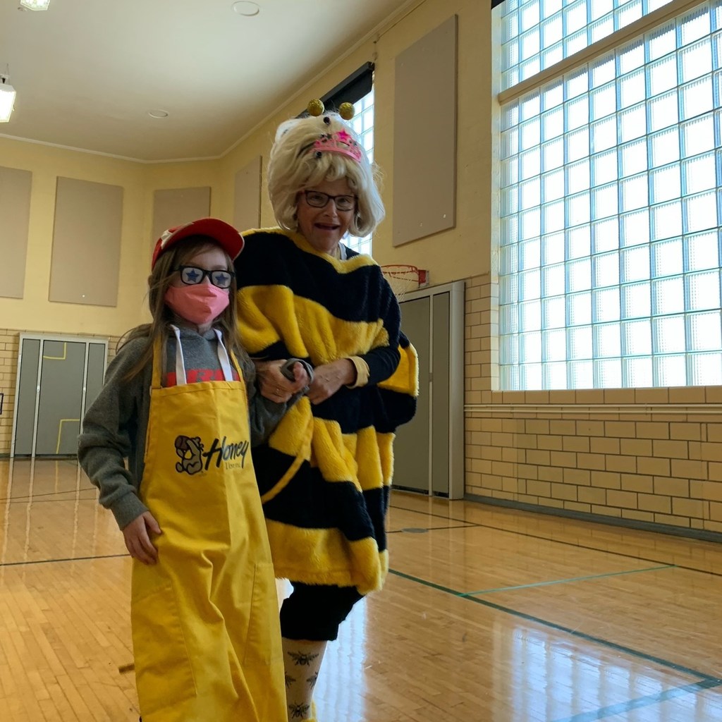 Adult and student in bee costumes