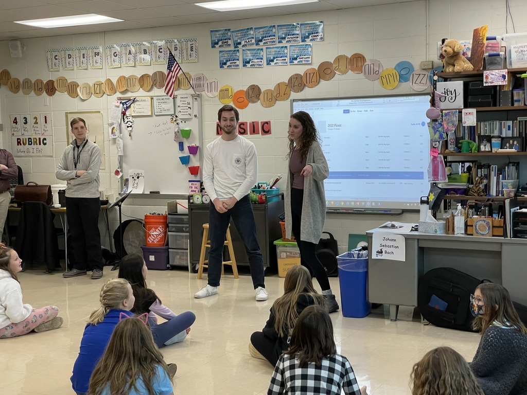 Two adults speaking to music class students