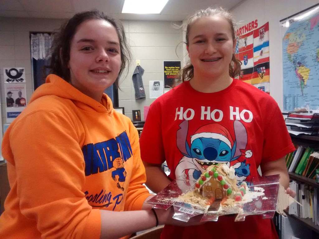 Two German Students holding a gingerbread house