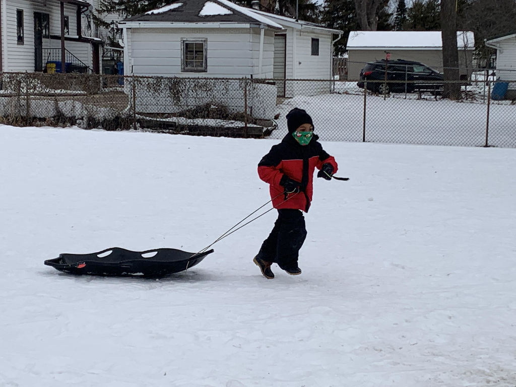 Boy pulling sled in the snow