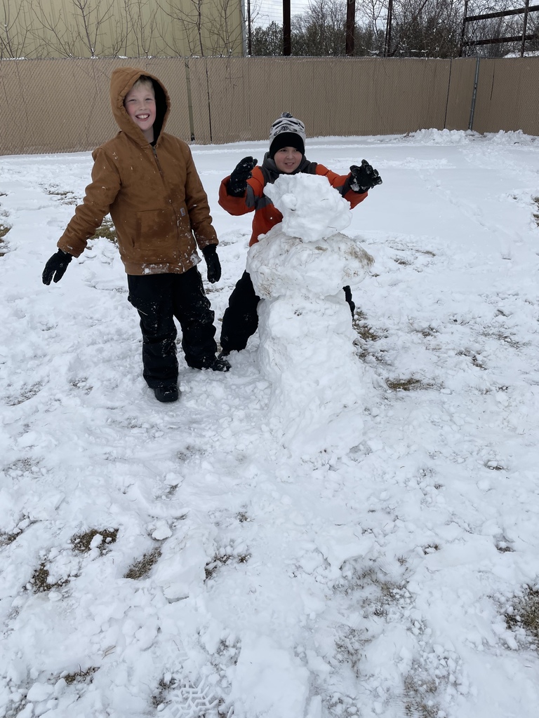 two boys building a snowman