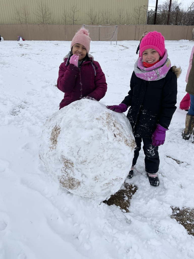 two girls with a large snow ball 