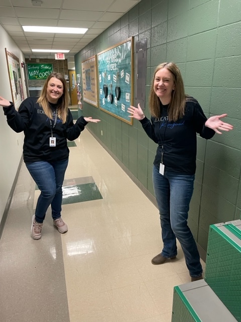 Two teachers holding their hands and arms out