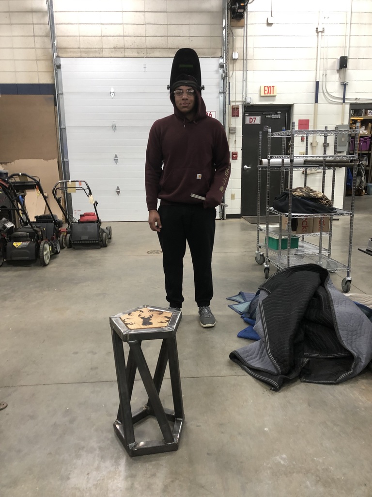 student and a welded stool he made
