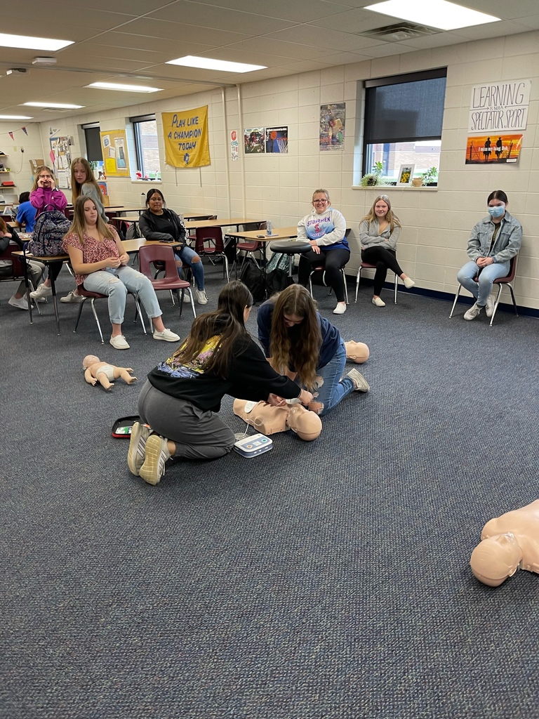 Students learning to use an AED machine