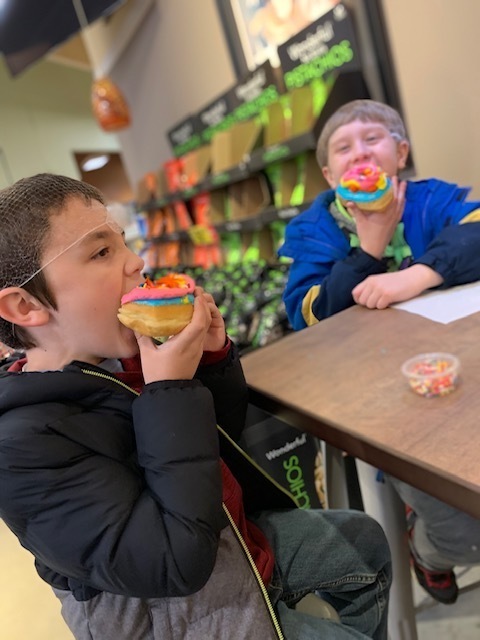 two boys eating donuts