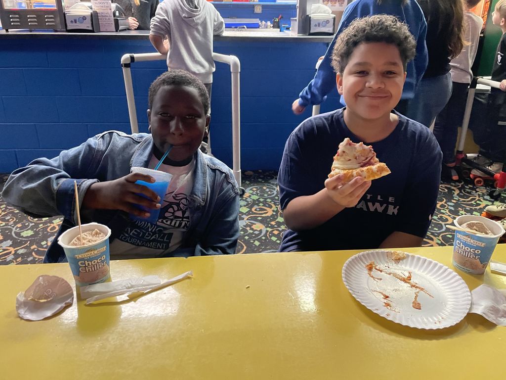 Two boys eating pizza