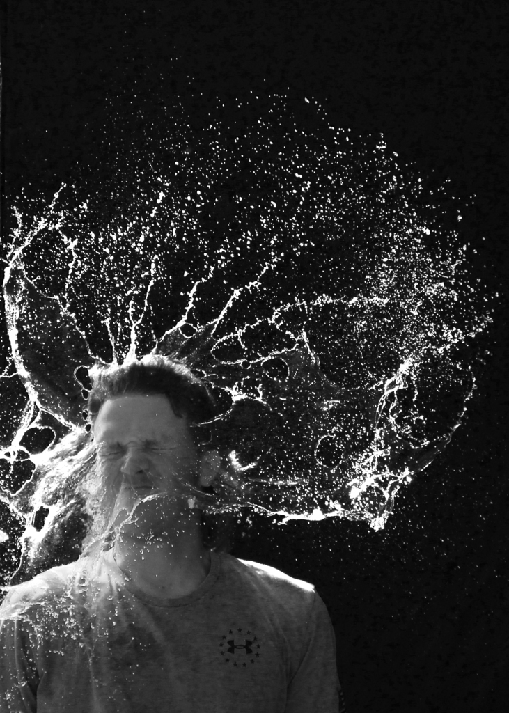 man getting water splashed in his face