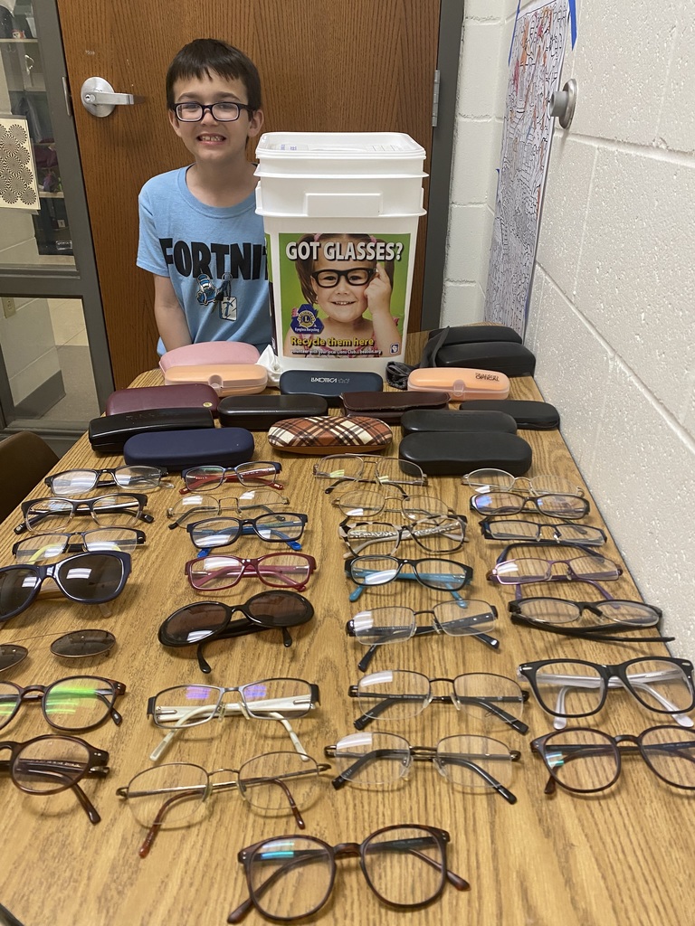 Student with lots of donated eyeglasses