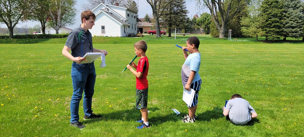 Students playing recorders outside