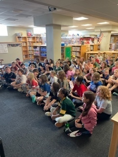 Librarian reading a book to students