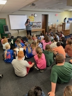 Librarian reading a book to students