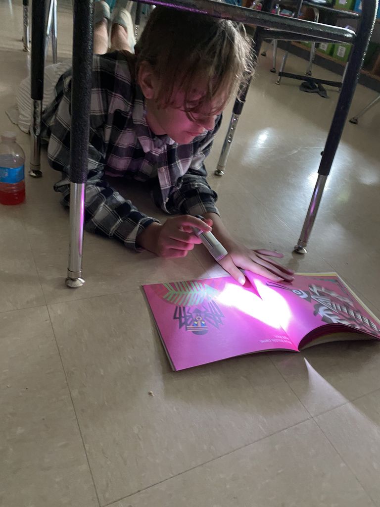 Child reading with a flashlight