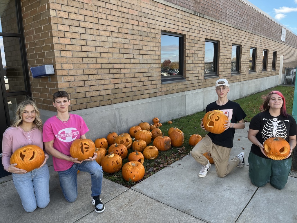 four students with carved pumpkins