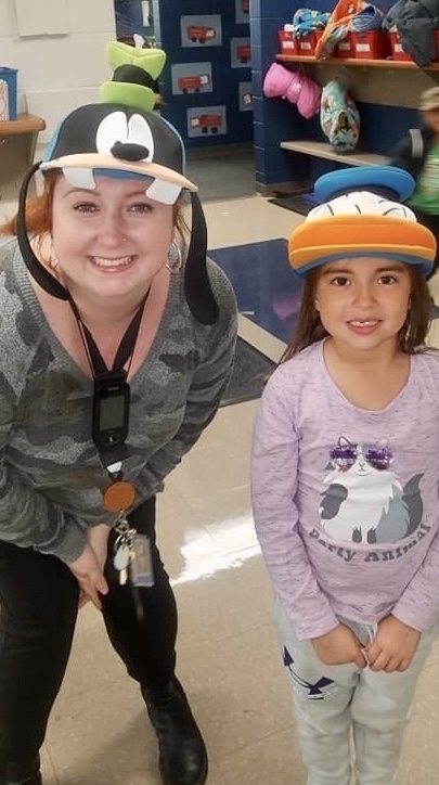 a staff member and student wearing hats