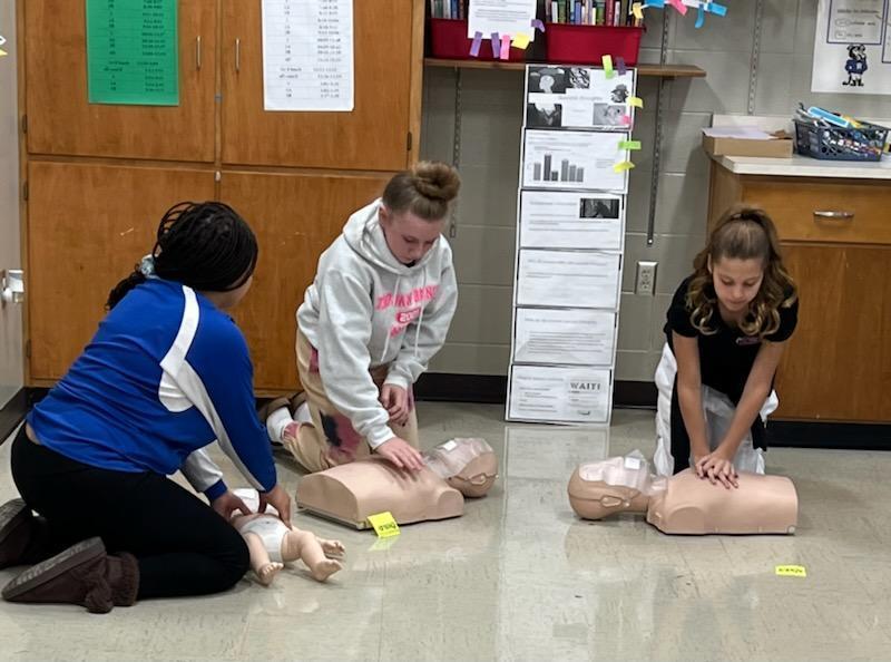 Students performing CPR on dummies